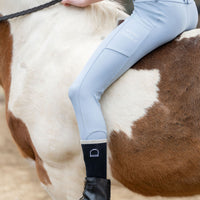 Little Girl riding a horse wearing light blue riding pants leggings and short stirrup socks and belt