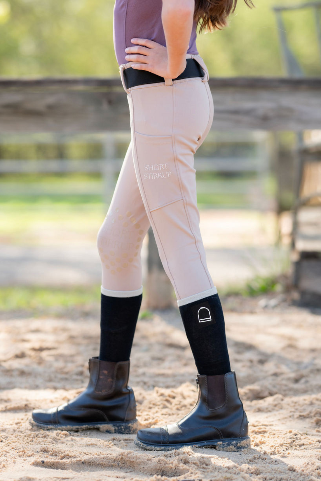 Girl in equestrian clothes wearing riding leggings and boot socks