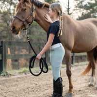 Girl holding pony wearing Soft sage leggings
