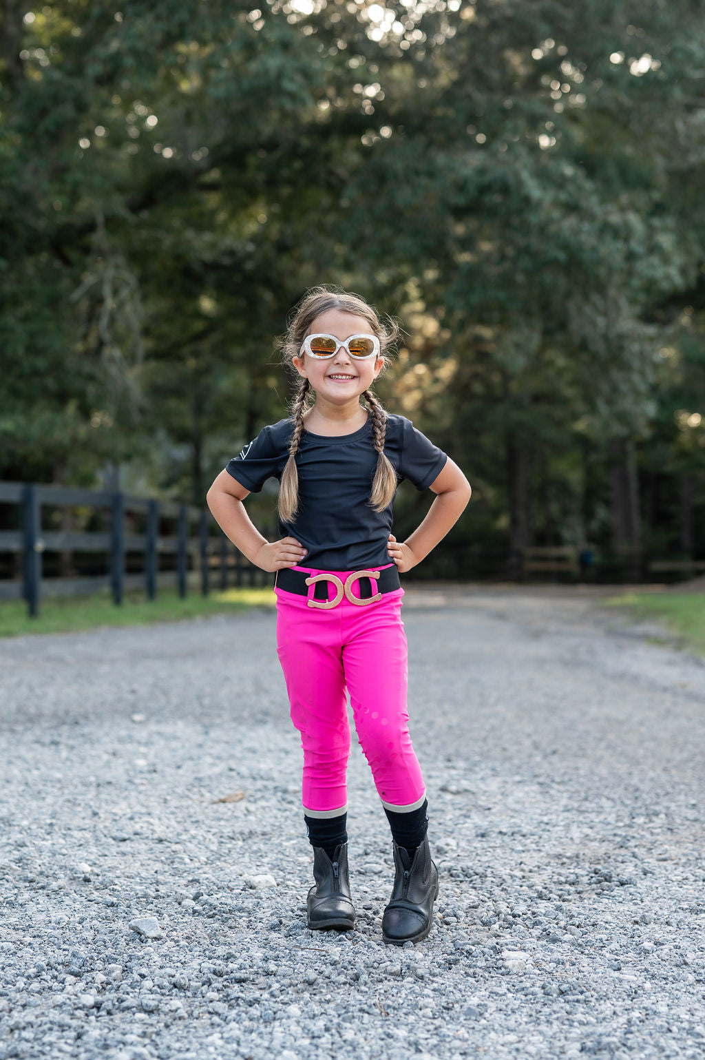 Little girl horse shoe belt equestrian clothes standing with sunglasses and hands on hip