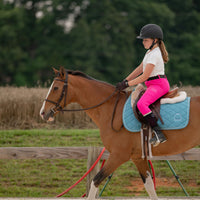 little girl equestrian riding a horse in hot pink leggings